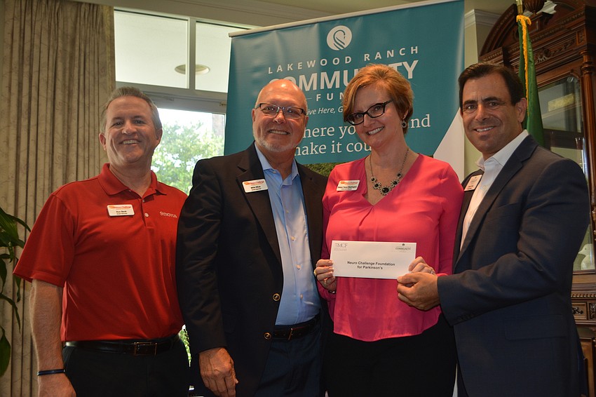 Neuro Challenge Foundation's Ron Beck, Mike Wick and Robyn Faucy-Washington receive a check for $5,000 from board member David Fink.