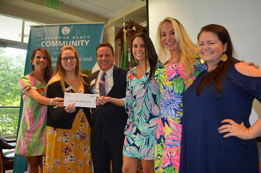 Board member Chris Romine, third from left, gives a check for $3,000 to the Junior League of Manatee County's Bobbi Jayne Vitale, Heather Coy, Lauren Geraldson, Amanda Broadway and Erika Lisch.