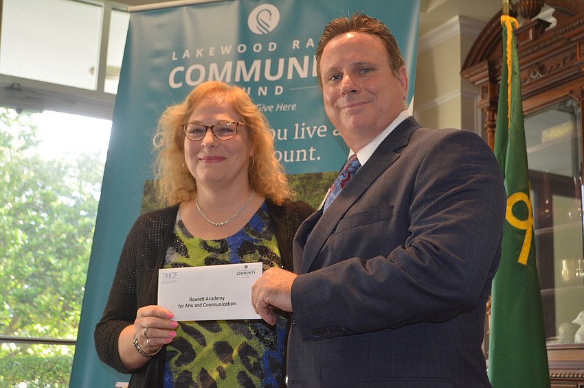 Kim McAfee of Rowlett Academy receives a grant for $2,350 from board member Chris Romine.