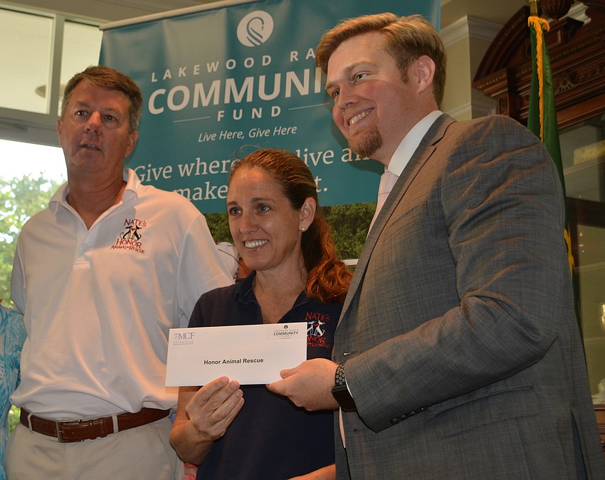 Rob and Dari Oglesby of Nate's Honor Animal Rescue accept a grant for $2,220 from President Garrett Shinn.
