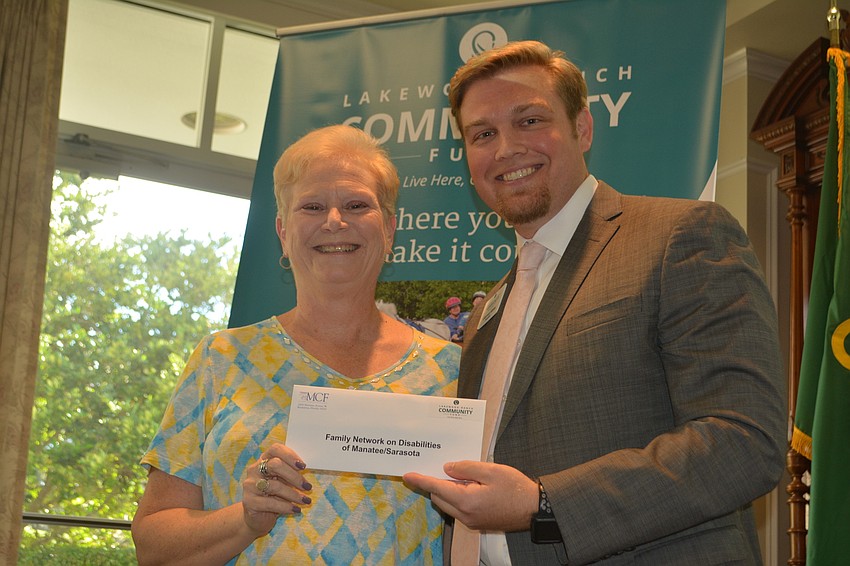 Executive Director Mary Smith of Family Network of Disabilities accepts a grant for $4,000 from President Garrett Shinn.