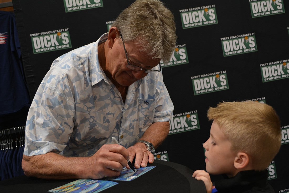 Guy Harvey signs an autograph for East County resident Davin Arnold, who came to the Dick&#39;s Sporting Goods opening with his family.