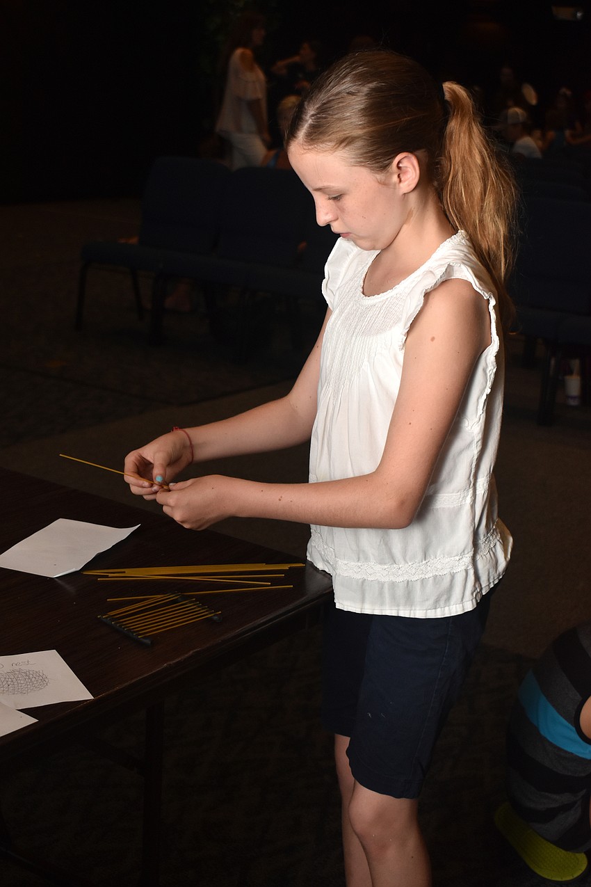 Mae Monnot makes a shark cradle at one of the Gills Club stations.