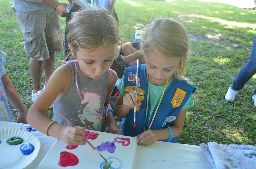 Bradenton's Alice Beaty of Troop 60, and Piper LeBretton of Troop 379), enjoy the Painting with a Twist booth.