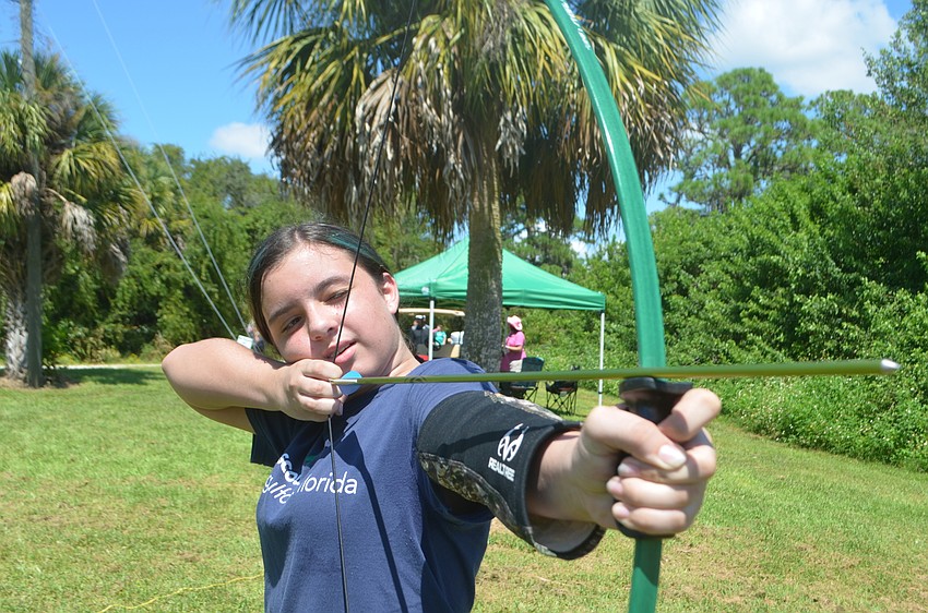 Bradenton's Hailey Lopez, 11, demonstrates archery to her fellow Girl Scouts.