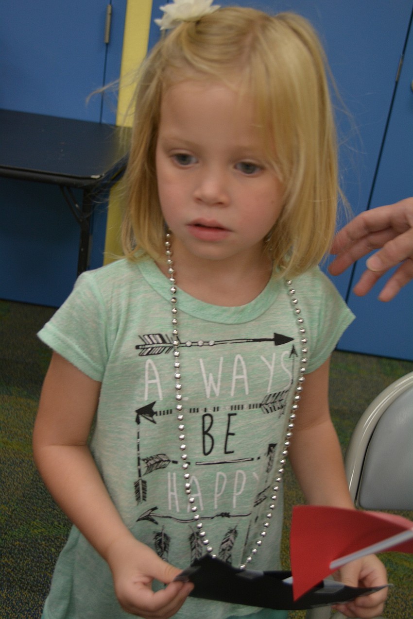 SKIP ----- East County's 4-year-old Elise Kapper makes a craft pirate ship from paper, tape, stickers and a drinking straw.