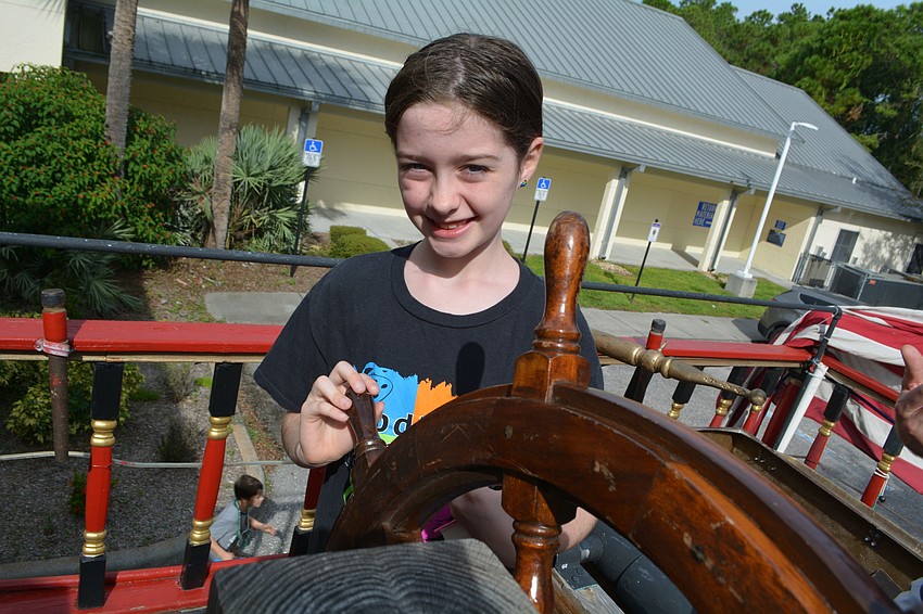 Eight-year-old Grace Lightburne tests her ship-driving skills before story time. She came with her brothers, Charlie and Mitchell, and dad, Jeff.