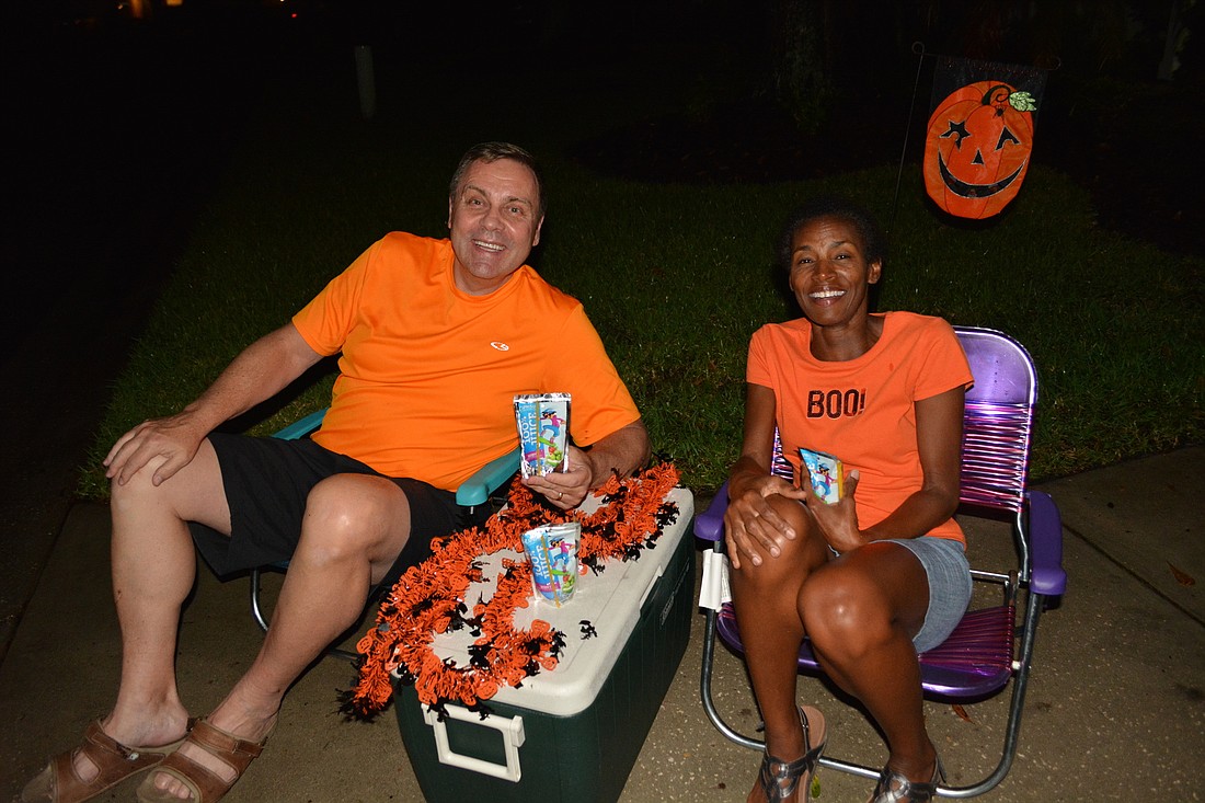 Lakewood Ranch&#39;s John Annis and Regina Morris give out juice drinks to trick-or-treaters, which works well for those frequently hot Halloween nights.  Some trick-or-treaters drink them right away.