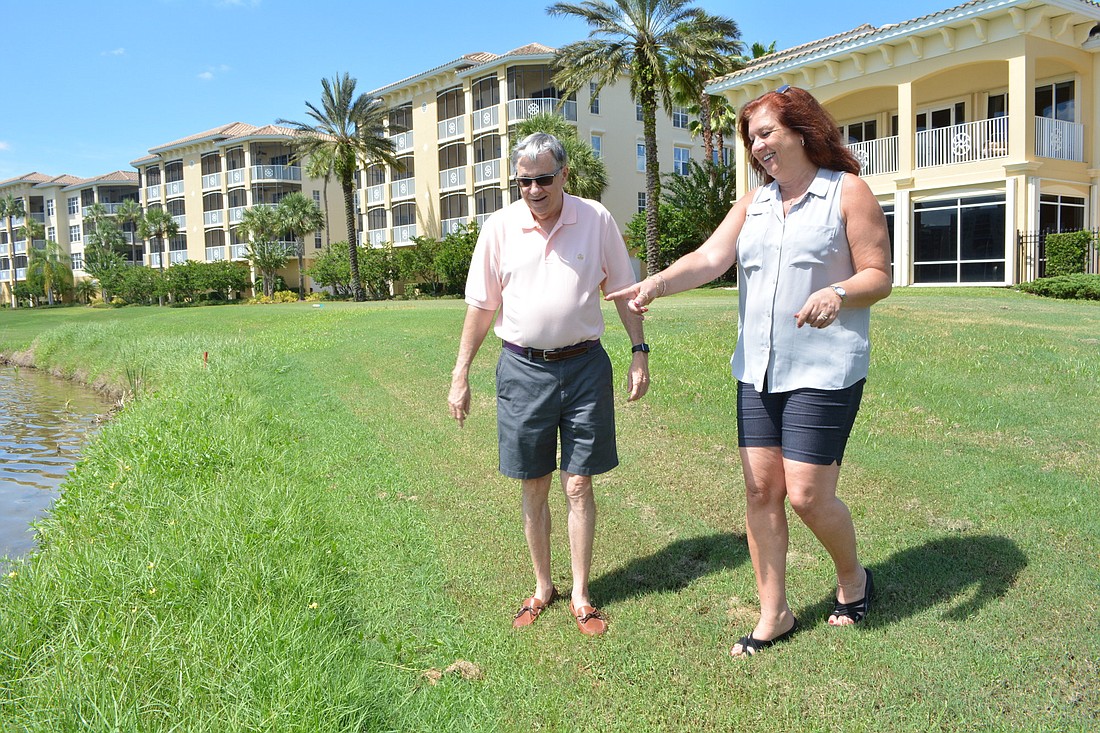 Watercrest resident Jerry Twiggs and Watercrest Condominium Association Property Manager Jeanne Moschella check for midge flies along the bank of Lake Uihlein.
