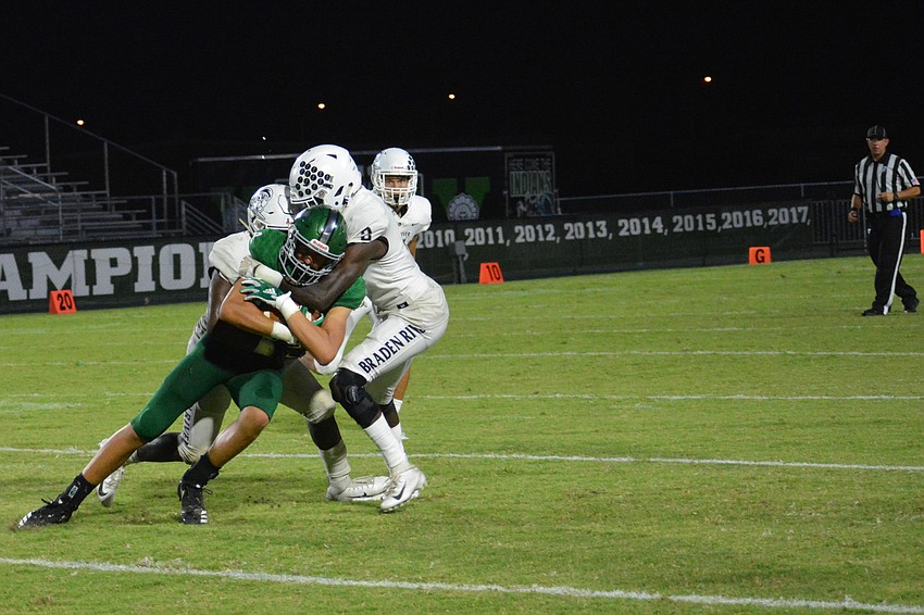 Senior cornerback Mark Davis (2) makes a strong tackle on a Venice High wideout.