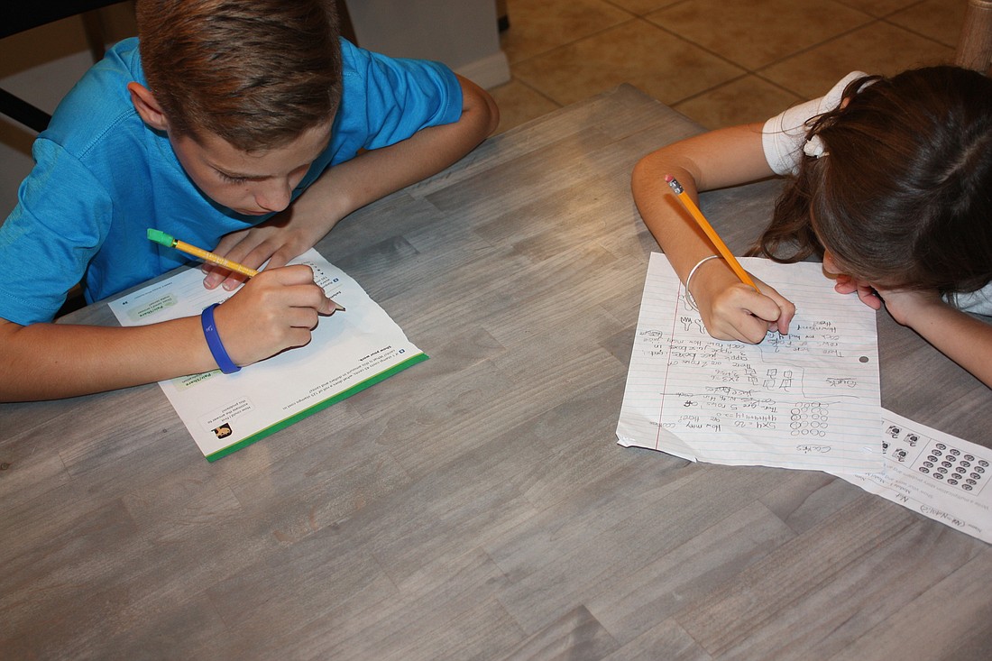 Michael Merino, a fifth-grader, and Natalie Merino, a second-grader at Willis Elementary, practice on their homework.