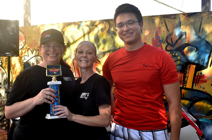 Amy Fuller and Angel Shova, of Sonny’s BBQ, which won Best Traditional Dish, with Sarasota Young Professionals Group Chairman Rob Young