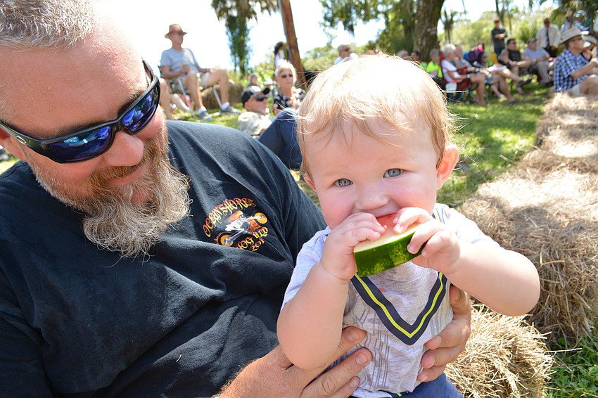Deklan Walker, 9 months, cools off on watermelon, much to the delight of his dad, Ryan Walker.