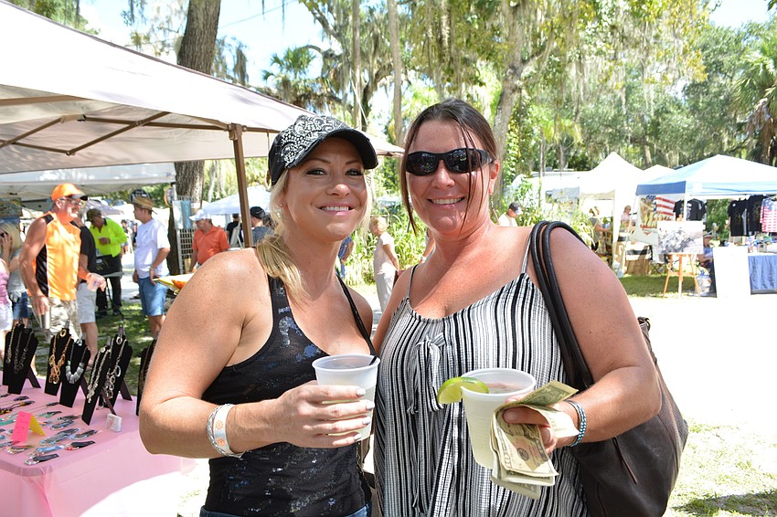 Sarasota's Jessica Abel and North Port's Amy Tetzlaff visit vendor booths as they listen to music.