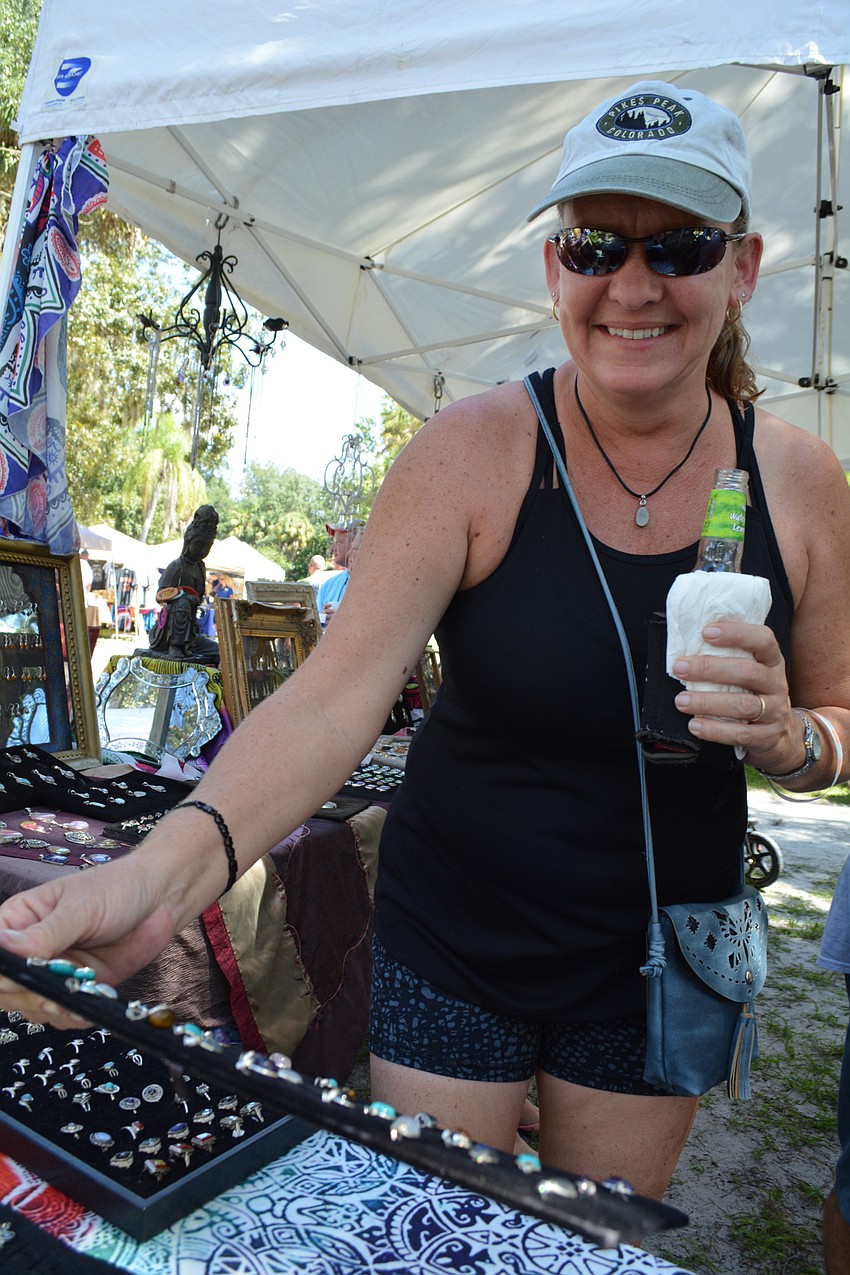 Sarasota's Sabine Koontz checks out jewelry at one of dozens of vendor booths.