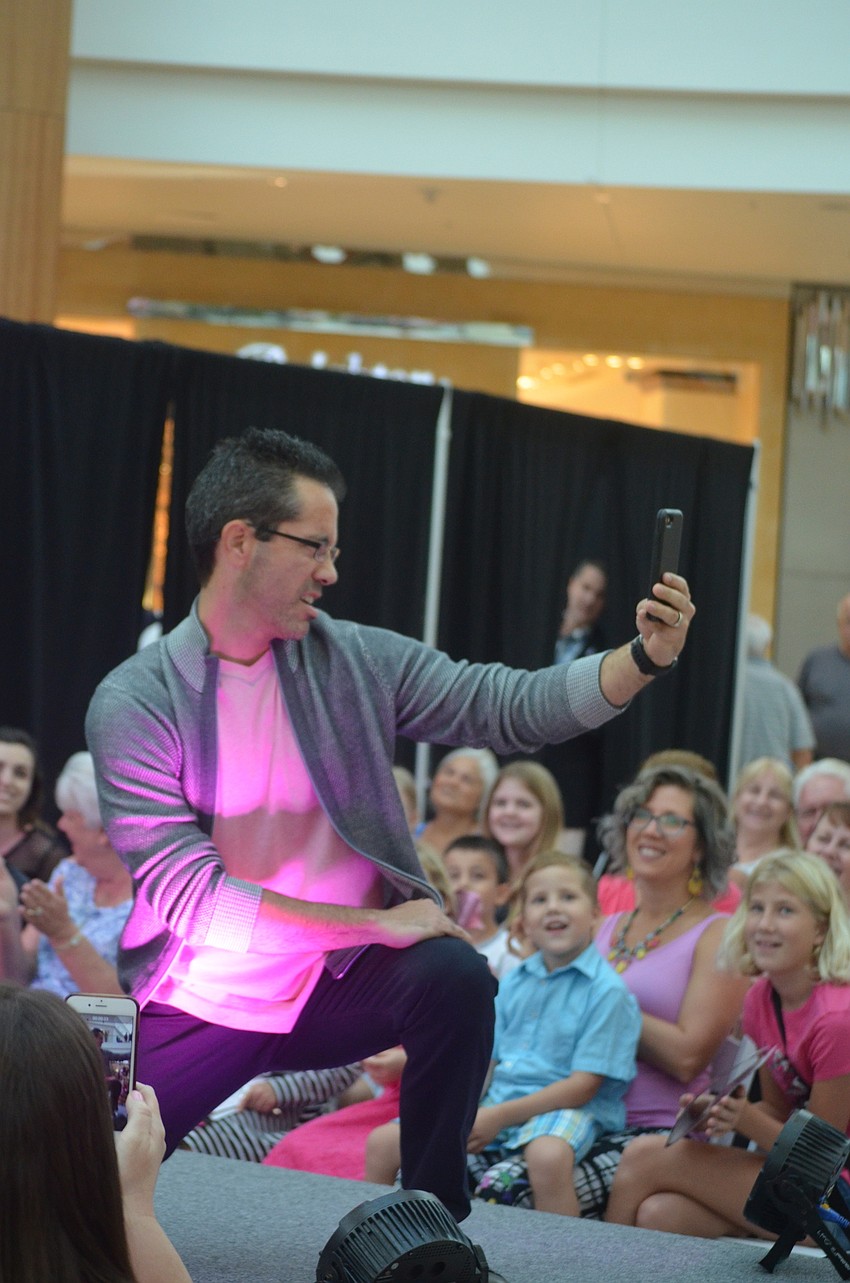 Punta Gorda's Casey Clough, an attorney, hams it up on the catwalk, stopping to take a selfie while he struts his stuff.