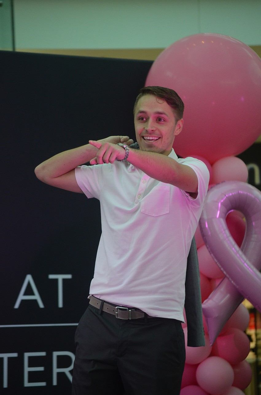 Justin Gorrell, the managing partner of Metro Diner, points to an audience member to hype up the crowd at the fashion show.