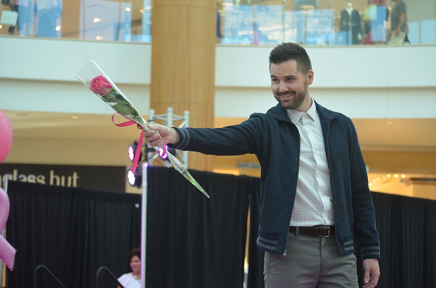 Dr. Trevor Born, from Sarasota Orthopedic Associates, offers his rose up to the audience when he walks the runway.
