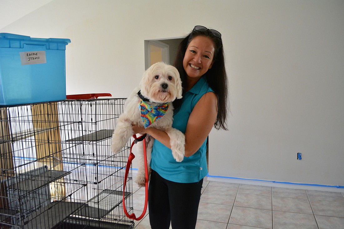 Volunteer Rebekah Boudrie shows off Toby, a poodle mix up for adoption, at the new location. A main house will be used for administration and other needs, while a separate building will house kennels.