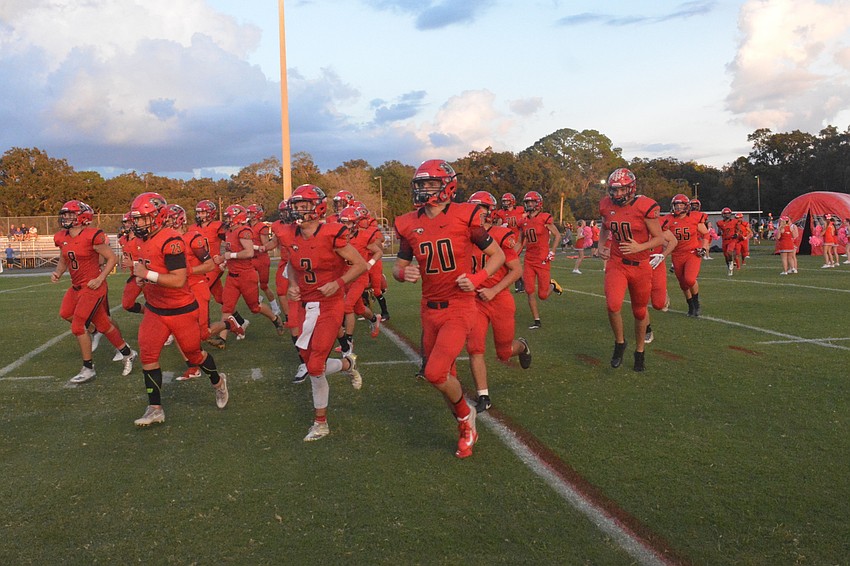 The Cougars take the field to start the game.