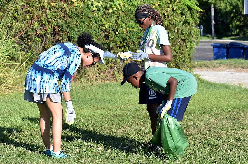 Broach School students check the grass of City Island for trash and monofilament.