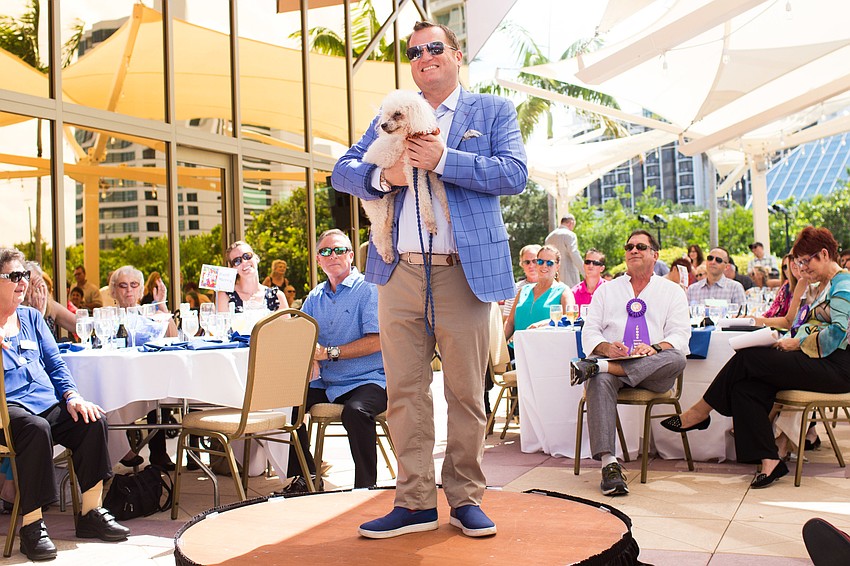 Brian Mariash poses for a photo with Ruth Merry's dog Jake.