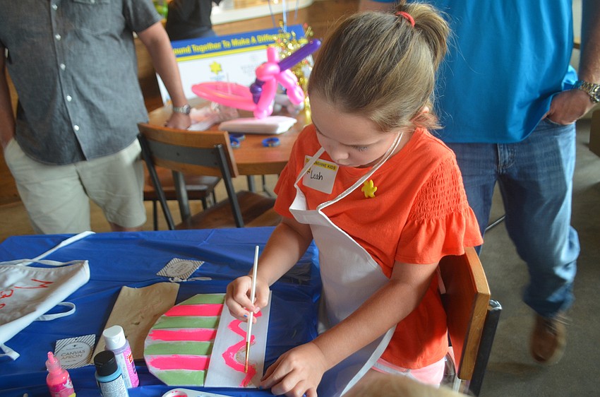 Heritage Harbour's Leah Glynn, 7, paints her chef's hat rainbow in preparation for creating her own pizza.
