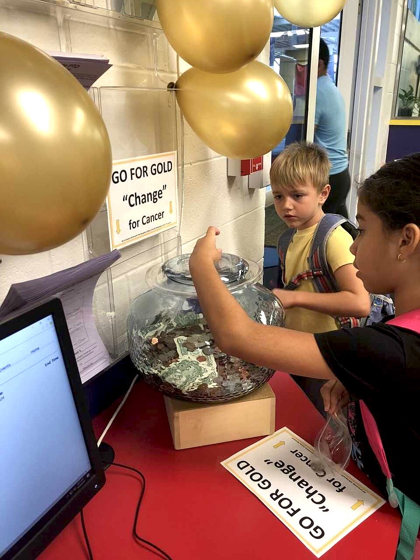 Gulf Gate Elementary students Carter Steinhoff and Ana Monsalve donate change for the Benjamin Gilkey Fund for Innovative Pediatric Cancer Research.