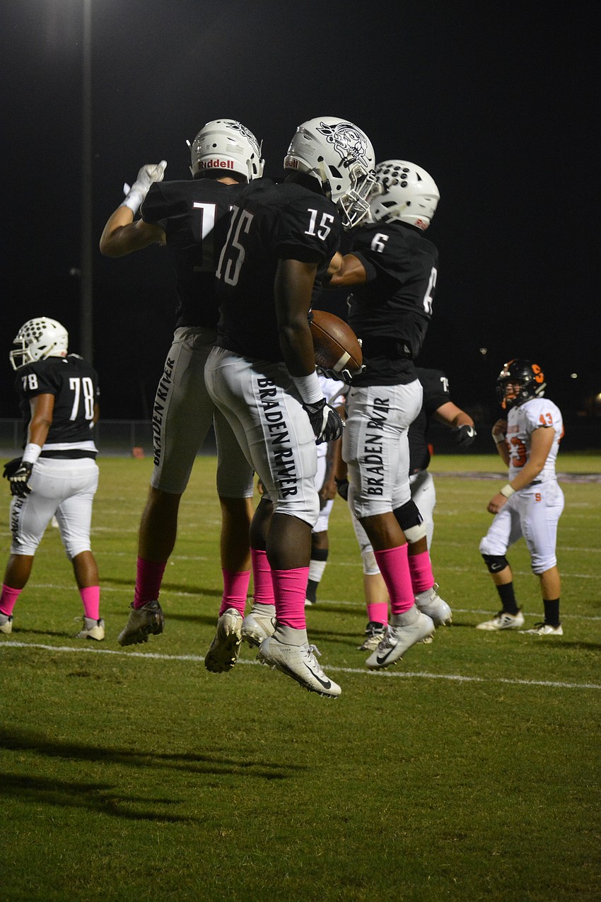 Pirates junior wideout Quinn McNulty (17), senior wideout Knowledge McDaniel (15) and junior running back Brian Battie (6) celebrate a McDaniel touchdown catch.