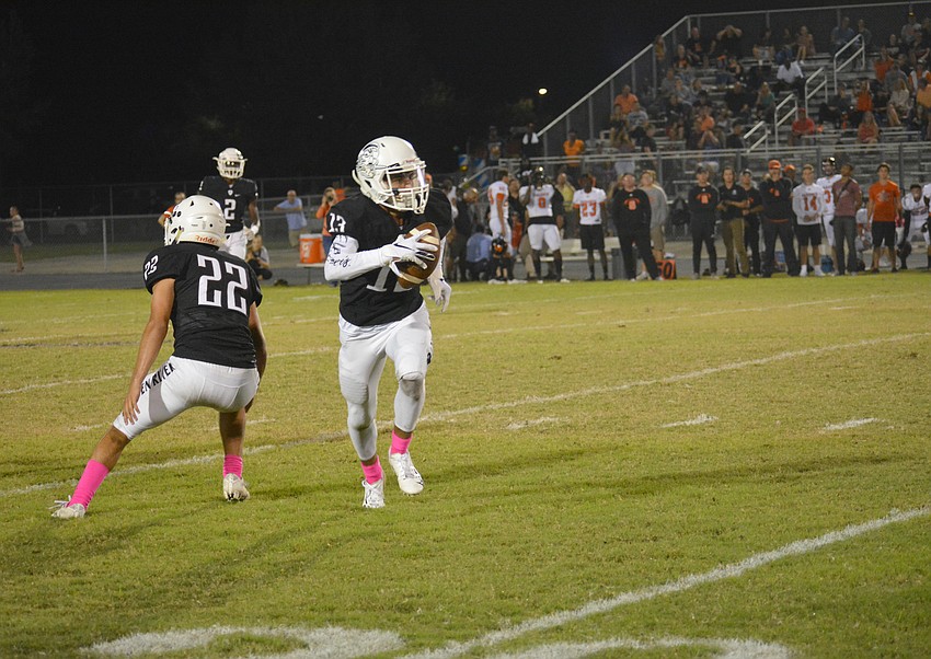 Pirates senior defensive back Jean Lugo-DeJesus (13) returns a Sarasota interception.