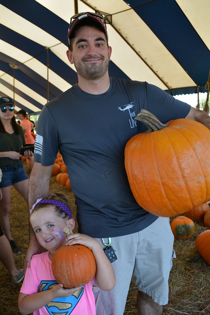 Four-year-old Ronin Weiner, of Parrish, and her dad, Mike, find the perfect pumpkins.