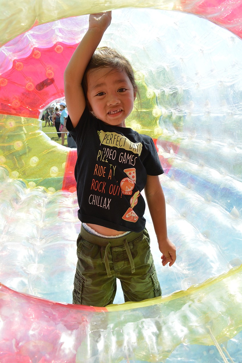 Tampa 3-year-old Quinton Santaines moves the inflatable tube across water.