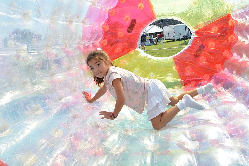 Siesta Key's Olivia Daley, 7, makes the inflatable tube roll itself across a water base.