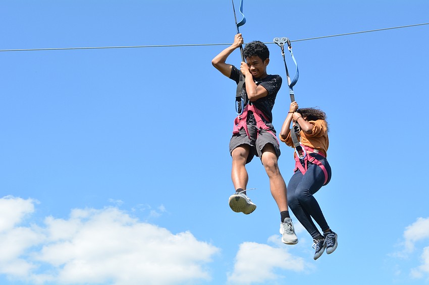 Brandon's Jamir Roberts, pictured with his friend Jocelyn Watson, speed down the zip line as their families videotape the experience.