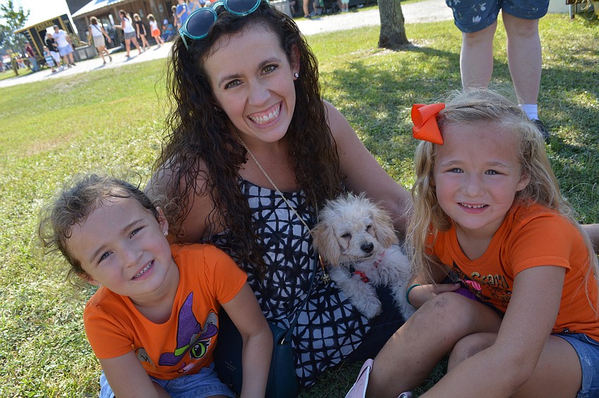 Emma, Emmie and Zoey Brown find a shady spot while they wait for Patrick Brown to return with funnel cake. The family resides in Port Charlotte.