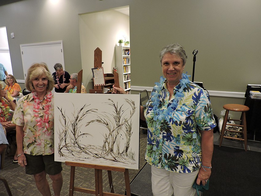 Sue Ann Iannello, right, stands next to her painting she donated to the event to be auctioned. Darlene Hoffmann, left, bought it for $300 with her husband, Ken, and donated it to disabled veteran Michael Monthervil.