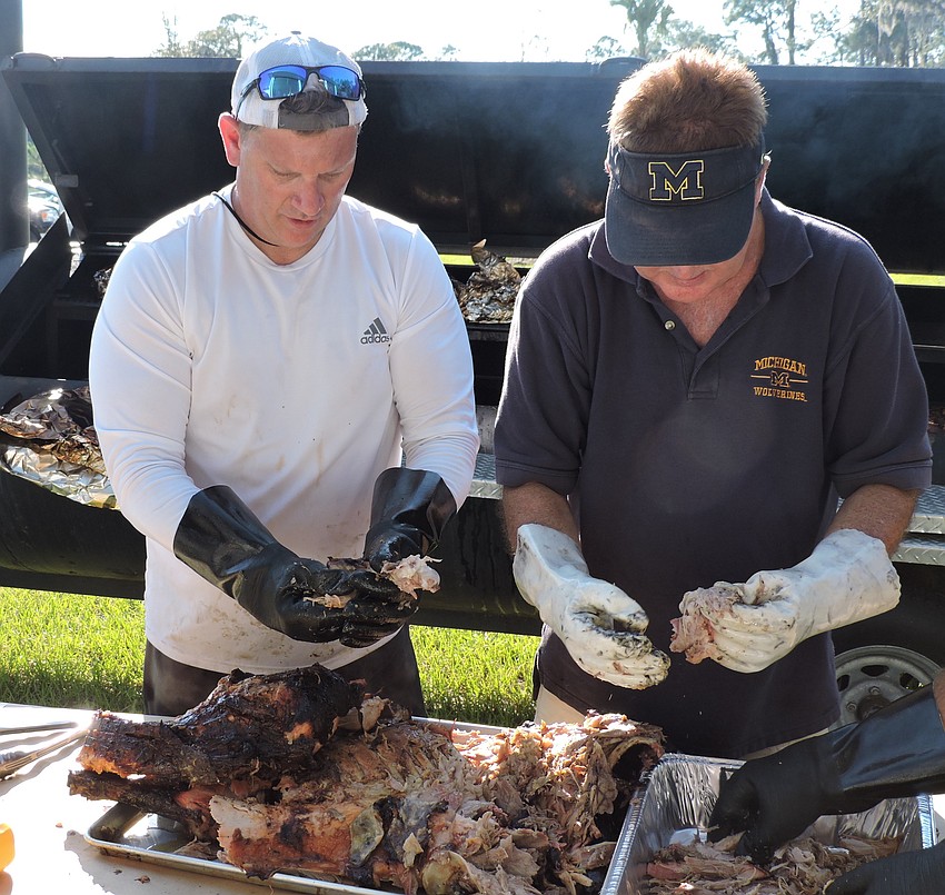 Volunteers Chuck Reda and Rick Browning prepare pork for the event.