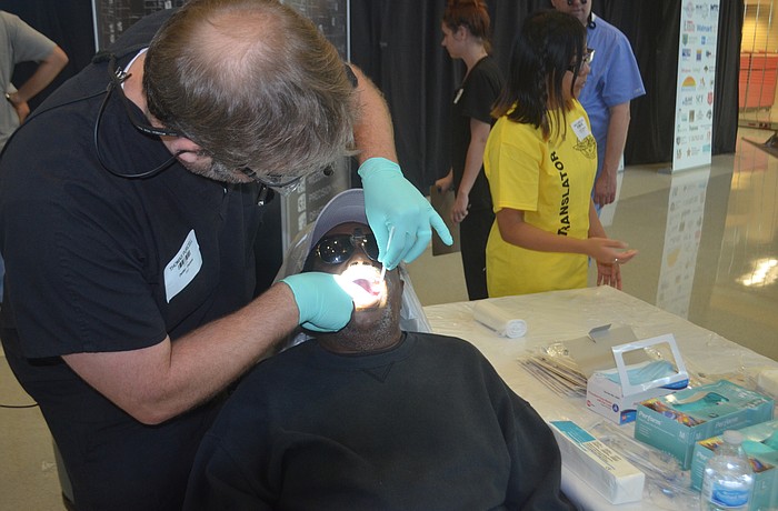 Lakewood Ranch's Dr. Thomas Purcell works on patient Willie Tate, who might need a tooth extraction.