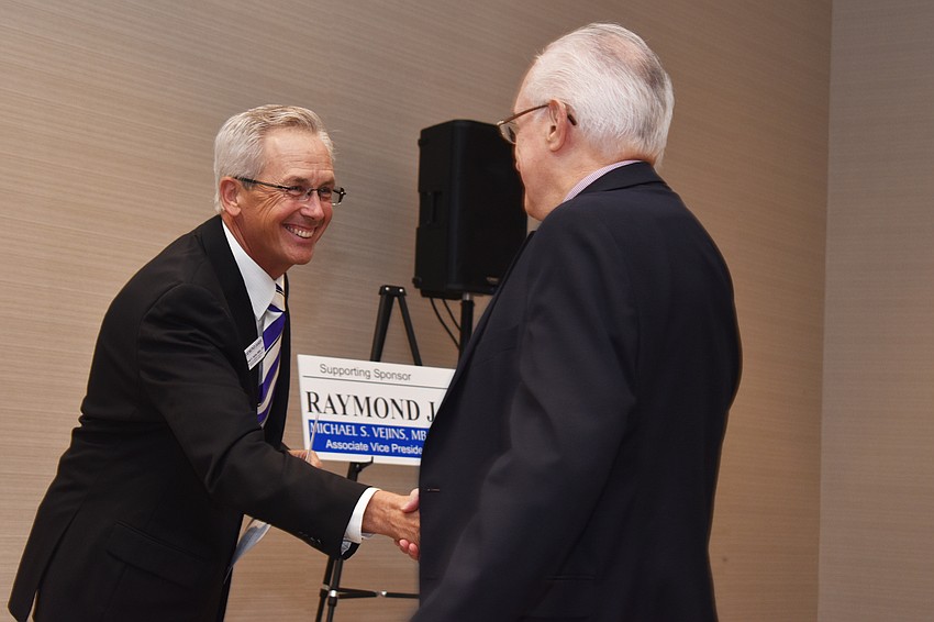 Michael Vejins shakes Dennis Hassell’s hand after he is announced as the third place winner in the Small Business Person of the Year (10 or less employees) category.