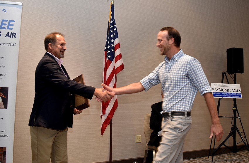 Mark Meador shakes Shane Catts’ hand as he is announced the first place winner in the Small Business Person of the Year (10 or less employees) category.