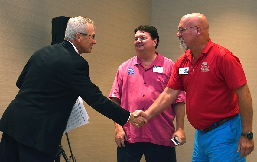 Michael Vejins congratulates John and Lynn Horne as they are announced the first place winners of the Small Business Person of the Year (11 or more employees) category.