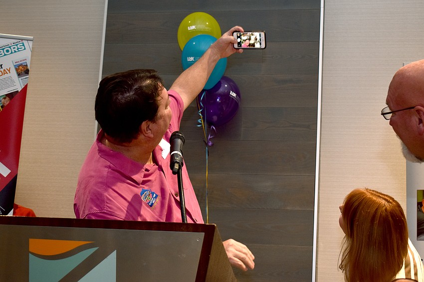 John Horne takes a selfie with the crowd as he accepts first place of the Small Business Person of the Year (11 or more employees) category.