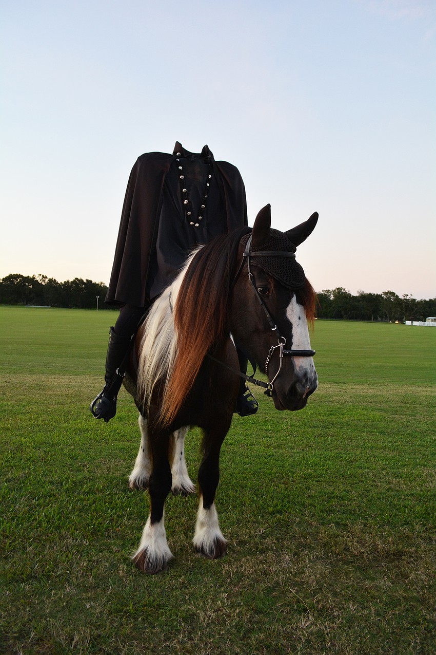 The Headless Horseman, played by Carmen Hanson, appears at the cemetery to chase away Ichabod Crane.