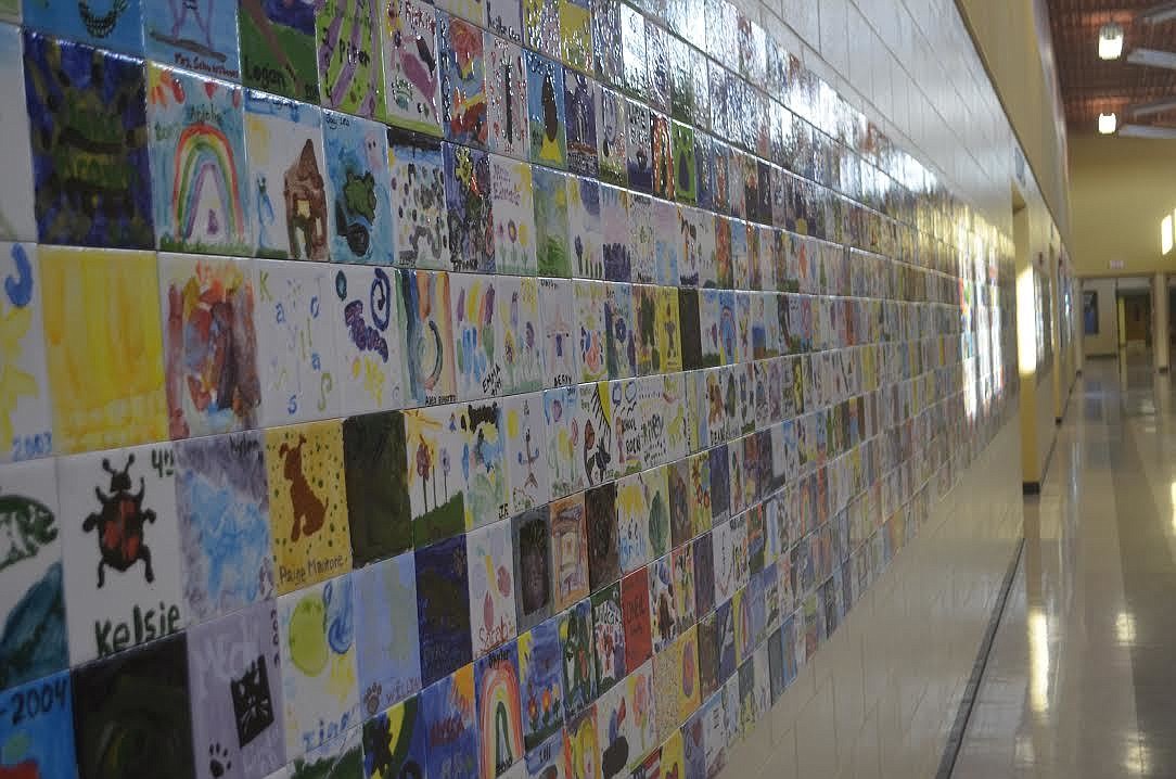 The tiles painting by the students are permanent fixtures to a hallway wall outside the main office.
