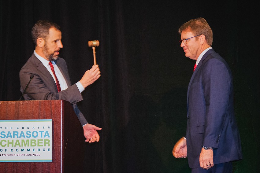 Chairman of the Board of Directors of The Greater Sarasota Chamber of Commerce Charlie Bailey hands the gavel to incoming chairman John LaCivita.