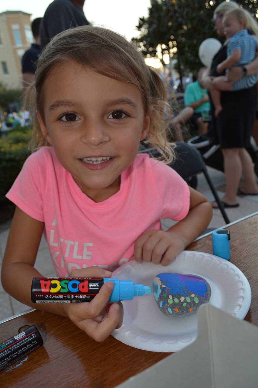 Natalie Gunia, 4, paints a rock as part of the LWR Kindness Project booth.