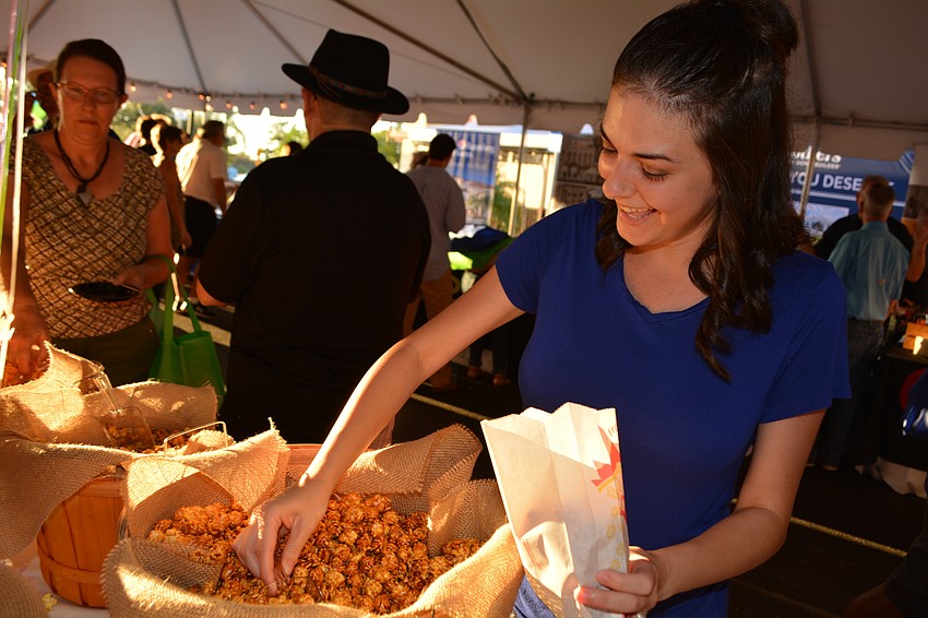 Michelle Ruck, who recently bought a home in Arbor Grande, fills up on popcorn in the area displaying Lakewood Ranch homebuilders.