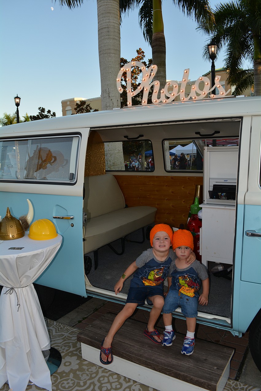 Jensen and  Greysen Lang, of Palmetto, like a photo booth set up . They sported their pumpkin hats for the evening.