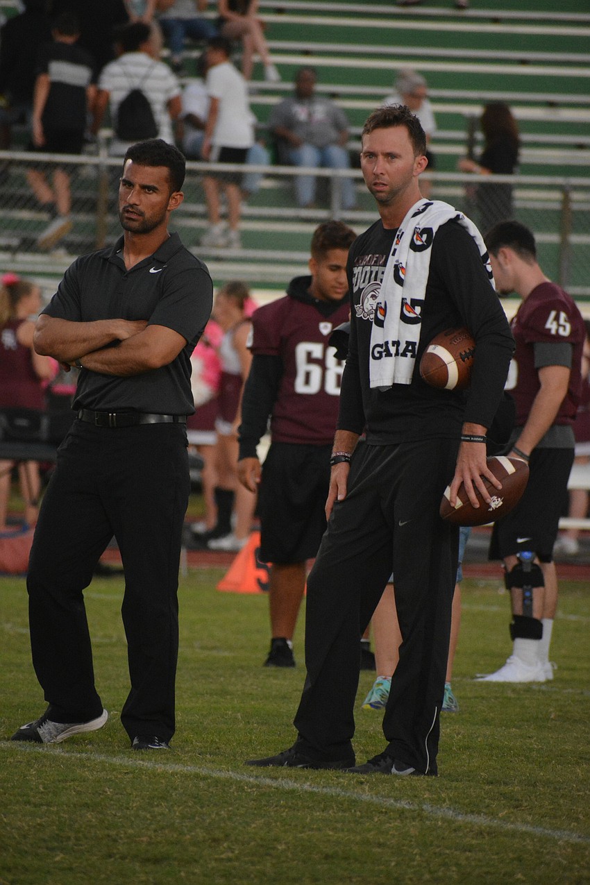 Braden River head coach Curt Bradley and  offensive coordinator Eric Sanders watch their team go through warmups. The Pirates would win 56-0.
