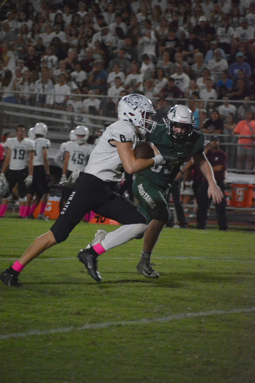 Pirates QB Bryan Gagg scrambles through the middle of the Mustangs defense. He finished 5 of 8 for 69 yards through the air.